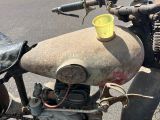 une vieille moto avec un gobelet jaune sur le guidon