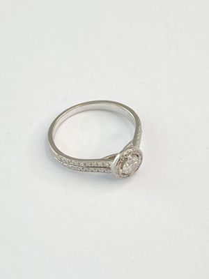 une image d'une bague en diamant sur une surface blanche