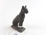 une statue représentant un chat assis sur une feuille de papier