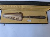 an antique silverware spoon in a black case on a white surface