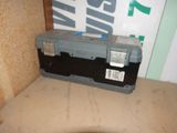une petite boîte à outils posée sur une boîte en carton
