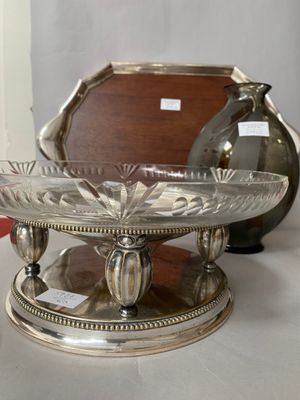 a silver plate on a table with a mirror in the background