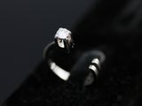 a close up of a diamond ring on a black surface