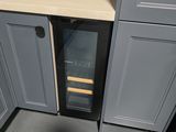 a small wine cooler in the corner of a kitchen