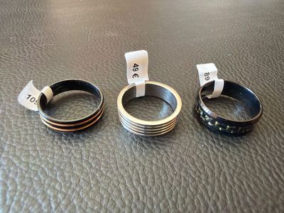 trois anneaux posés sur une surface en cuir