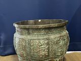 an old bronze pot sitting on a wooden floor next to a blue wall