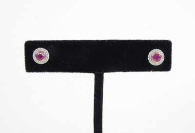 une paire de boucles d'oreilles à clous en rubis et diamants, présentée sur un socle en velours noir