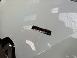 a close up of a white car with a sticker on it ' s hood