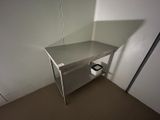 une photo d'une table de travail en acier inoxydable sur laquelle se trouve un rouleau de papier toilette