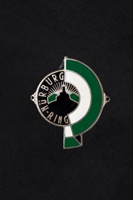 a close up of a green and white badge on a black surface
