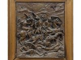 un relief en bronze représentant un homme à cheval dans un paysage