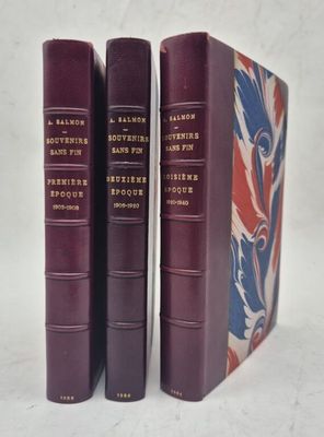 trois livres sont empilés sur une surface blanche