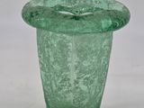 a green glass vase that is sitting on a table