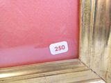 une photo d'un cadre doré sur fond rouge