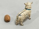 a figurine of a sheep and a walnut on a table