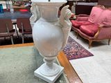 un vase blanc posé sur une table au milieu d'une pièce