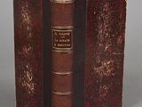 an old book with a brown cover sitting on top of a table