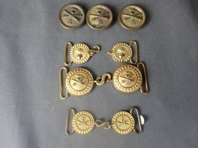several different types of brass buttons on a blue cloth