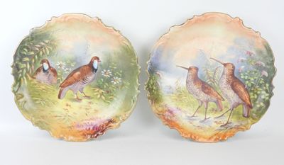 deux assiettes avec des oiseaux peints dessus, posées sur une table