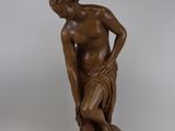 l'image d'une statue d'un homme assis sur un rocher