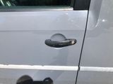 a close up of a car door handle with a shadow on the ground