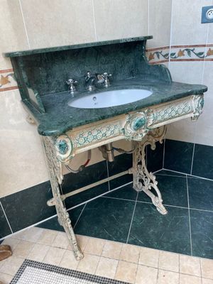 a green marble sink in a bathroom with a tiled floor