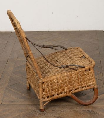 une chaise en osier posée sur un sol carrelé