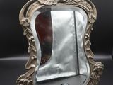 a silver mirror sitting on top of a black table