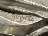 a close up of a metal object with a name on it