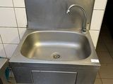 un lavabo et une poubelle dans des toilettes publiques