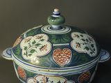 a green and blue bowl with a lid on a table