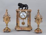 a clock with a lion on top of it next to two vases