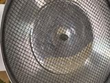 a close up view of a metal strainer on a rug