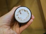une personne tenant une tasse de café sur laquelle est dessiné un smiley