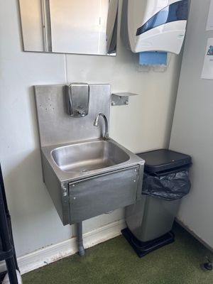 un lavabo et une poubelle dans un coin de la salle de bains
