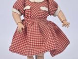 a doll that is wearing a red dress and black shoes