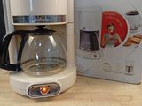 une cafetière posée sur une table à côté d'une boîte