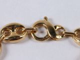 an image of a close up of a gold bracelet on a white surface