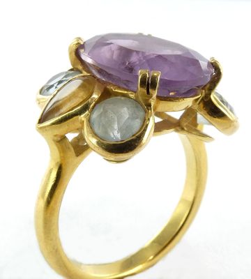 une image montrant un gros plan d'une bague en or sertie d'une pierre violette