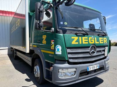 un camion vert garé devant un immeuble