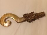 an antique brass hook with a decorative design on it