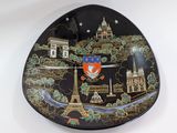 a black plate with a picture of a city on it