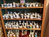 il y a beaucoup de tasses et de soucoupes sur les étagères de cette pièce