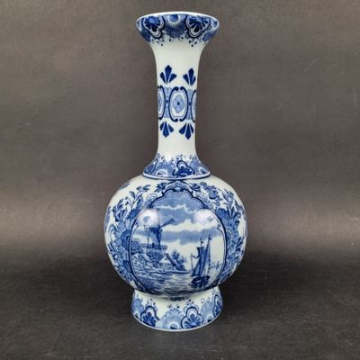 an old blue and white vase with a picture of a boat in the water