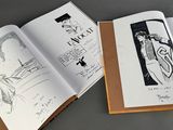 two open books with drawings on them on a table