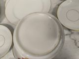 a person holding a cup and saucer on a table