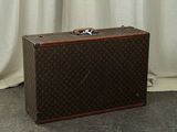 a suitcase sitting on the floor in front of a curtain
