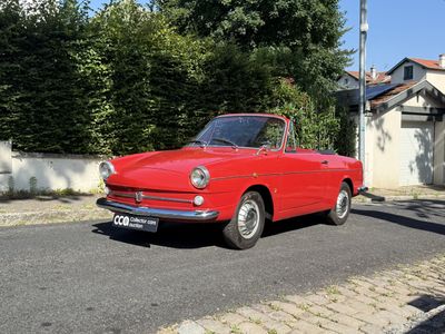 une voiture rouge garée sur le bord de la route
