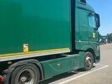 a green truck that is parked in a parking lot