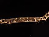 an image of a close up of a gold bracelet with a name plate